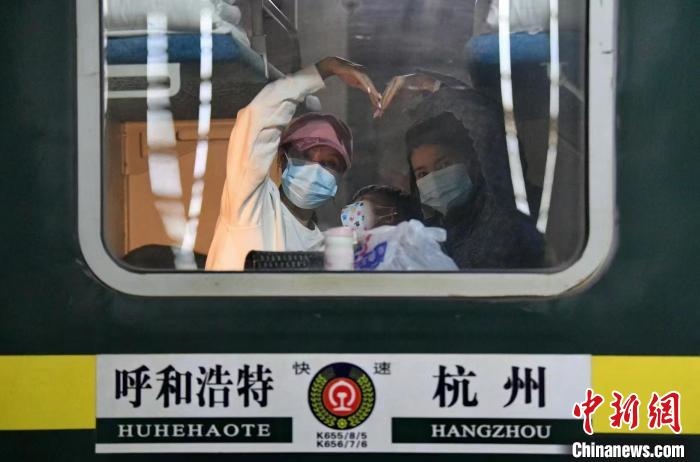 圖為登上轉(zhuǎn)運(yùn)火車的游客向額濟(jì)納比心?！⊥趵?攝
