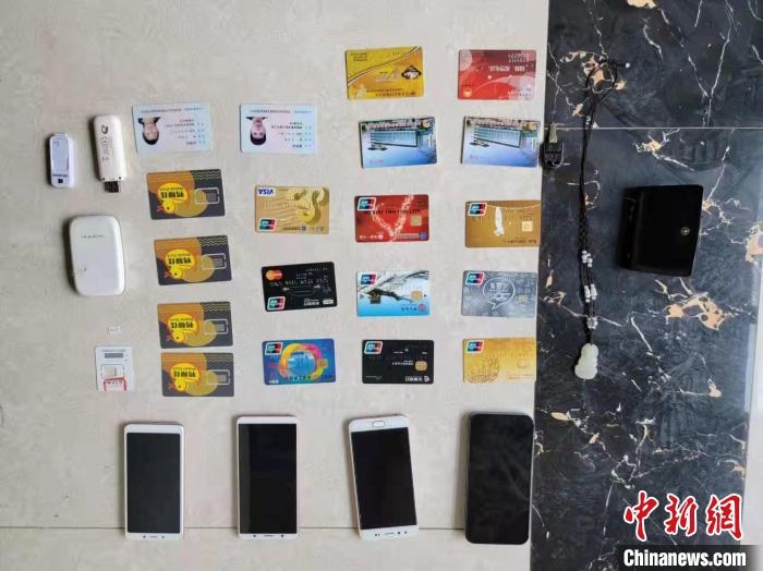 資料圖為果洛藏族自治州公安民警查扣的作案手機(jī)和涉案銀行卡?！‖斍呖h公安局供圖