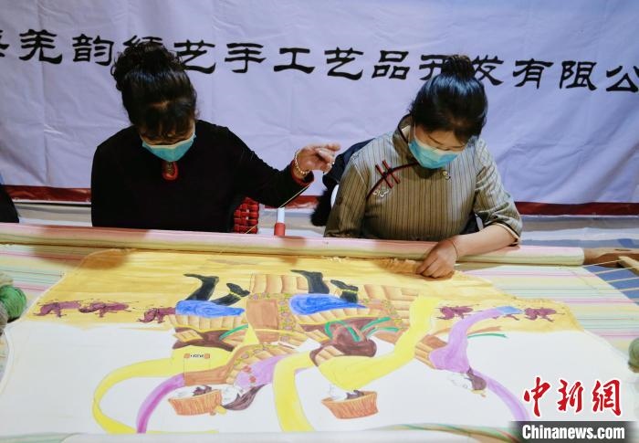 圖為皮繡藝人在市集上“秀”指尖技藝?！●R銘言 攝