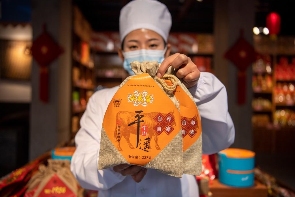 1月27日，在平遙古城南大街的一家平遙牛肉店內(nèi)，工作人員展示一款牛肉產(chǎn)品。新華社記者 楊晨光 攝