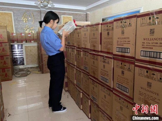 資料圖為檢察人員核對查獲的假冒品牌白酒。青海省人民檢察院供圖