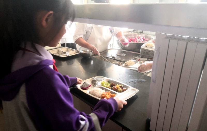 伊金霍洛旗第一小學學生正在打飯，今天的飯菜是三菜一湯外加水果，學生可以多次盛取，吃飽為止。人民網(wǎng)記者 孫博洋攝