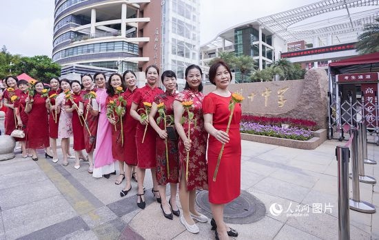 6月7日一早，廈門雙十中學(xué)考生家長們身穿旗袍，手拿向日葵在考場外為孩子加油打氣，寓意“旗開得勝，一舉奪魁”。人民網(wǎng)記者 陳博攝