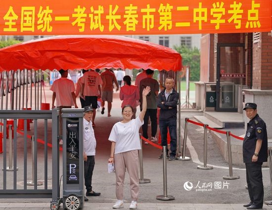 6月7日，在長春市第二中學(xué)考點，一名考生信心滿滿進(jìn)入考場，并與家長揮手致意。人民網(wǎng)記者 李洋攝