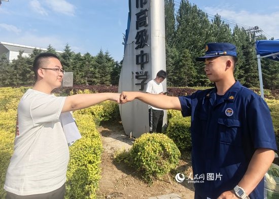 6月7日，遼寧營口老邊區(qū)消防救援大隊的消防員為高考學(xué)子加油助威。人民網(wǎng)記者 尹柏寒?dāng)z