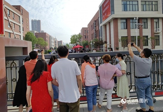 6月7日，武漢市第三中學(xué)考點，考生進(jìn)場后，家長在柵欄外用手機拍攝自己的孩子。人民網(wǎng)記者 郭婷婷攝