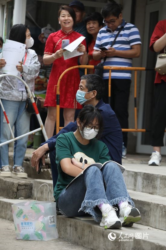 6月7日，沈陽市第一中學(xué)，學(xué)子靠在父親身邊做最后的沖刺。人民網(wǎng) 周頌雪攝