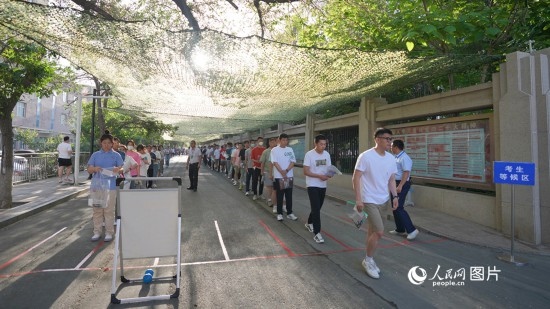 6月7日，烏魯木齊市第七十中學(xué)門口，考生們有序進(jìn)入考場。人民網(wǎng) 李欣洋攝