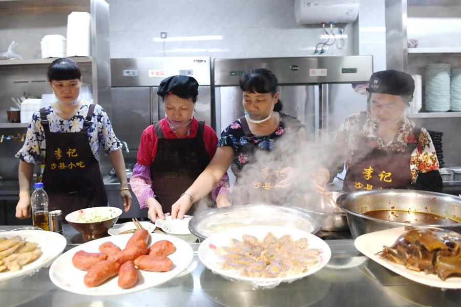 福建三明市沙縣區(qū)一家小吃店工作人員在為客人準(zhǔn)備特色小吃。 新華社記者 林善傳 攝