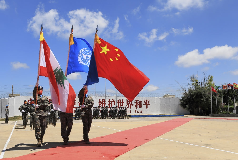 在黎巴嫩南部辛尼亞村的中國維和部隊營區(qū)，中國維和部隊官兵在受勛后通過觀禮臺（2022年7月1日攝）。聯(lián)合國駐黎巴嫩臨時部隊（聯(lián)黎部隊）當日授予中國第20批赴黎巴嫩維和部隊全體410名官兵聯(lián)合國“和平勛章”，以表彰他們?yōu)槔璋湍勰喜康貐^(qū)和平穩(wěn)定作出的突出貢獻。新華社記者 劉宗亞 攝