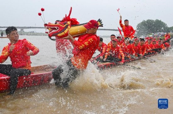 6月22日，在湖南省岳陽市湘陰縣湘江臨資口水域，參加龍舟賽的隊員接“龍頭”下水。