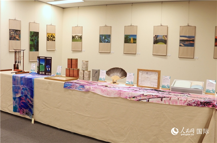 現(xiàn)場(chǎng)展出的馮學(xué)敏攝影作品與湖州市特色工藝品。（人民網(wǎng) 許可攝）