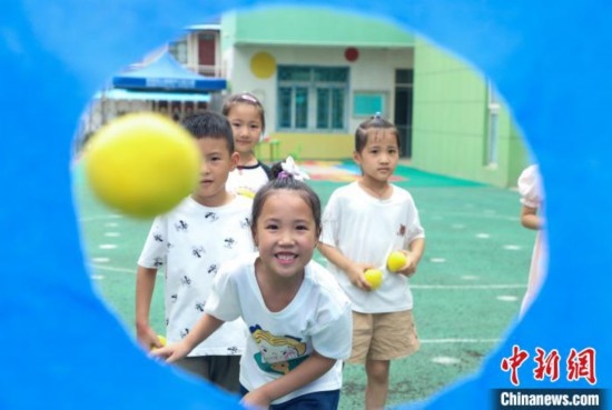 在肥西縣山南鎮(zhèn)中心幼兒園，孩子們在玩布洞投球游戲。陳家樂 攝