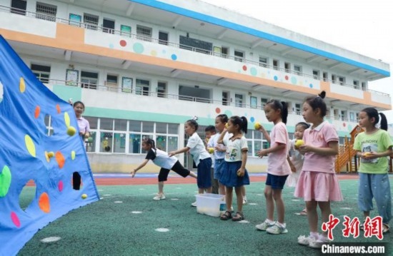 在肥西縣山南鎮(zhèn)中心幼兒園，孩子們在玩布洞投球游戲。陳家樂 攝