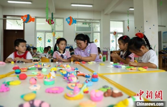 在肥西縣山南鎮(zhèn)中心幼兒園，孩子們在老師的指導(dǎo)下做彩色泥塑。陳家樂 攝