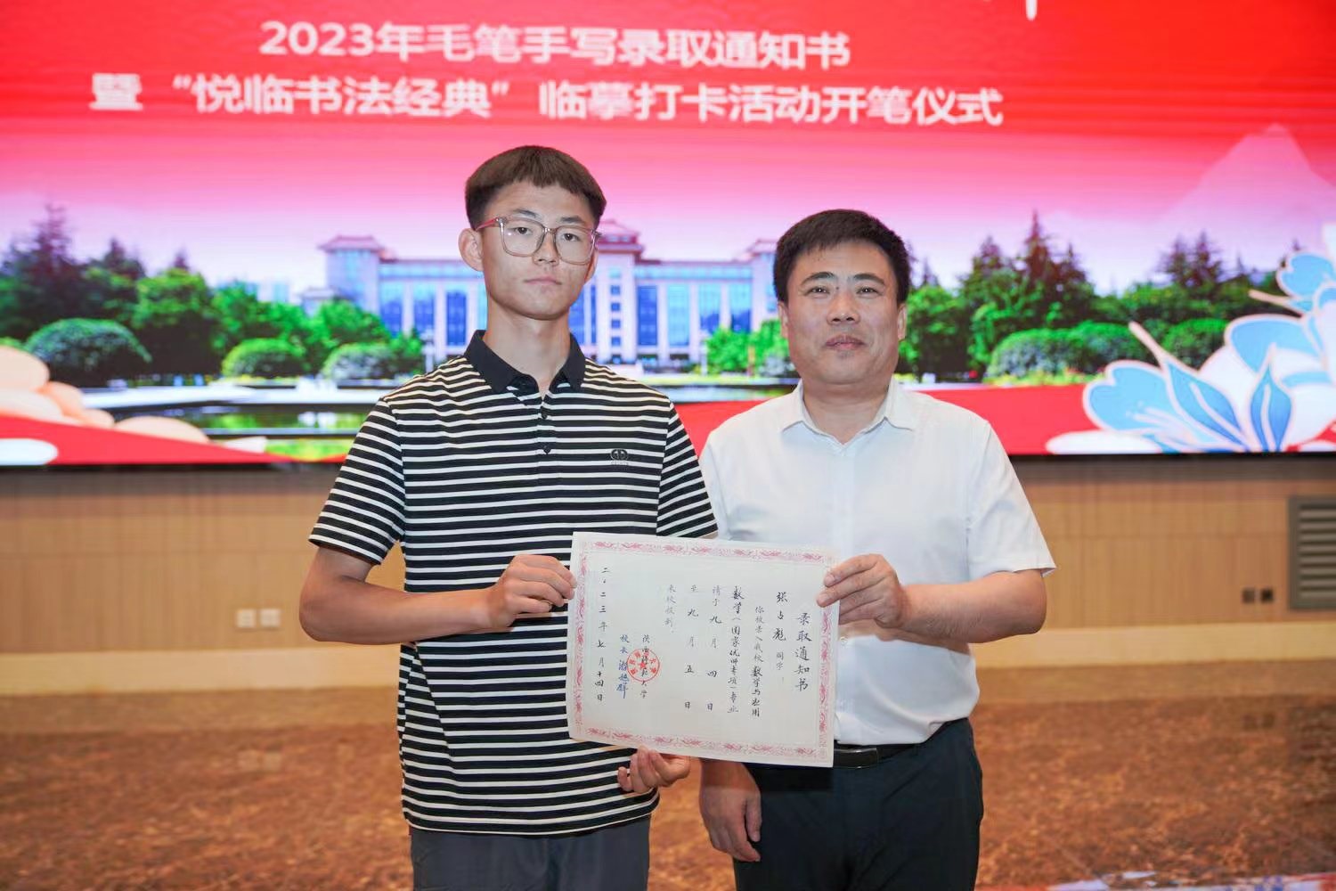 陜西師范大學(xué)黨委書記李忠軍為2023級新生代表張占彪同學(xué)發(fā)放錄取通知書。校方供圖
