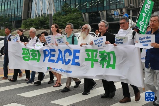 7月22日，在韓國首爾，人們手舉標(biāo)語參與反戰(zhàn)游行。新華社發(fā)（楊暢 攝）