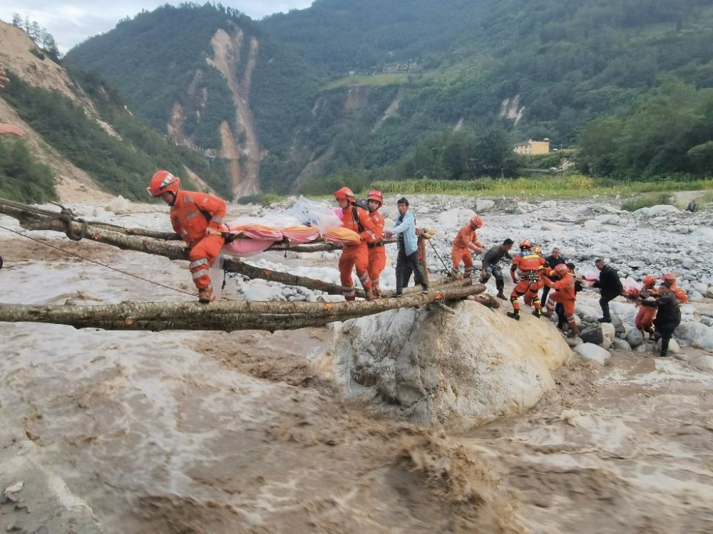 ↑2022年9月5日，武警四川總隊(duì)機(jī)動(dòng)第二支隊(duì)官兵在甘孜州瀘定縣磨西鎮(zhèn)磨子溝村搭建臨時(shí)木橋轉(zhuǎn)移被困群眾（手機(jī)照片）。新華社發(fā)（洪福樂 攝）