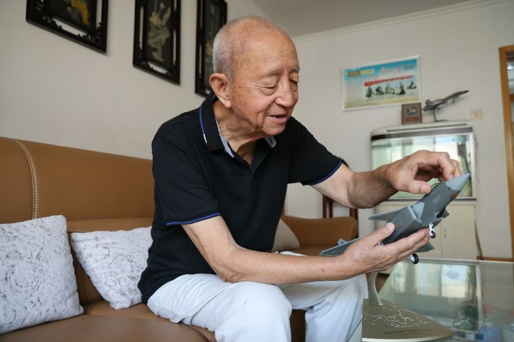 ↑2023年7月24日，新中國第一代飛行員陶偉在家中擦拭殲-20飛機(jī)模型。新華社發(fā)（張瑞 攝）