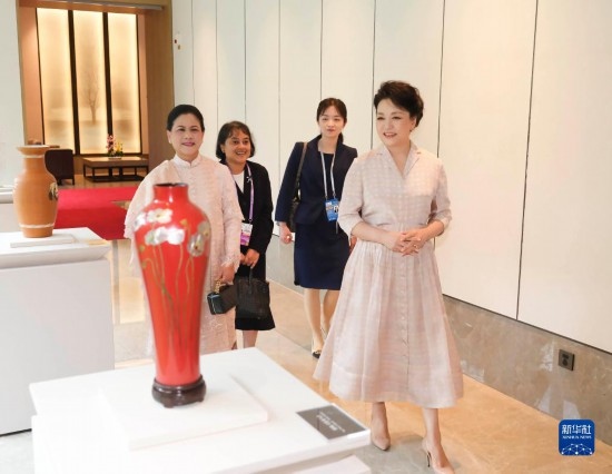 7月27日下午，國(guó)家主席習(xí)近平夫人彭麗媛在四川成都會(huì)見陪同印度尼西亞總統(tǒng)佐科來華出席第31屆世界大學(xué)生夏季運(yùn)動(dòng)會(huì)開幕式并訪華的總統(tǒng)夫人伊莉亞娜。這是彭麗媛和伊莉亞娜欣賞成都特色非遺工藝品。新華社記者 丁林 攝