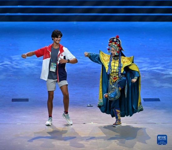 7月29日，美國運動員杜恩（左）在聯(lián)歡會現(xiàn)場與川劇演員互動。新華社記者 蔡湘鑫 攝