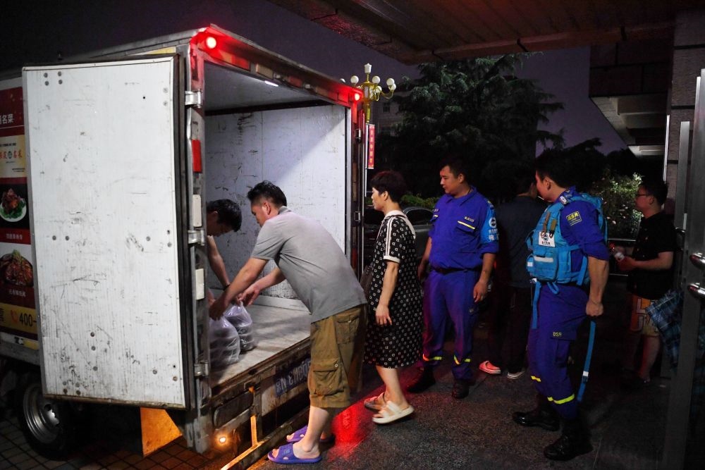 河北省涿州市職教中心安置點的工作人員在運送飯菜，準備發(fā)放給安置群眾（8月1日攝）。新華社記者 牟宇 攝
