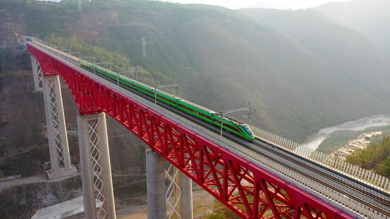 中老鐵路國際旅客列車在云南省境內(nèi)的元江特大橋上飛馳。姚巍攝
