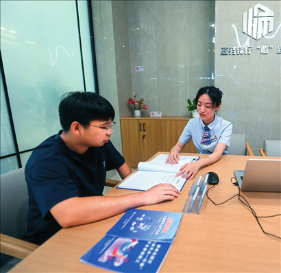 在杭州市臨安區(qū)政務(wù)服務(wù)中心的“為企服務(wù)中心”，黨員志愿者（右）解答企業(yè)主的疑問（2023年7月7日攝）。徐昱攝/本刊