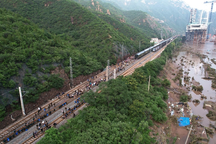 8月2日，受困列車旅客在救援人員幫助下徒步趕往轉(zhuǎn)運(yùn)客車（無(wú)人機(jī)照片）。新華社記者 張晨霖 攝