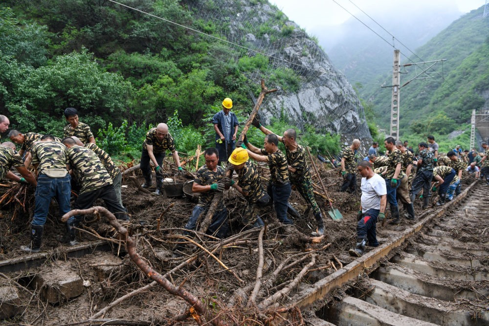 8月1日，在北京市門頭溝區(qū)水峪嘴村附近一段被阻斷的鐵路線上，中鐵六局工作人員在清理軌道上的雜物，全力恢復(fù)交通。新華社記者 鞠煥宗 攝