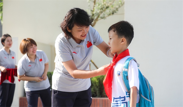 8月30日，雄安史家胡同小學(xué)學(xué)生體驗(yàn)學(xué)校生活。老師為學(xué)生佩戴校徽。