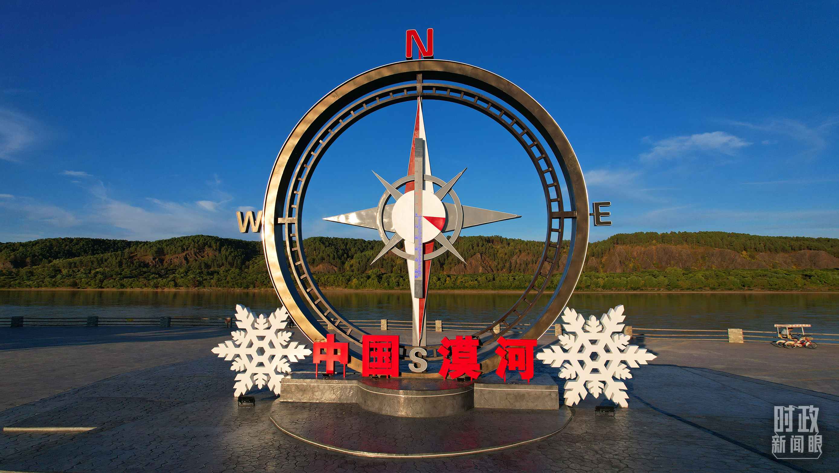 △指北針雕塑是北極村標志性建筑之一，其紅色指針指向正北方。上面的大型溫度計高12.22米，象征北極村位于東經(jīng)122°20′。（總臺央視記者范凱拍攝）