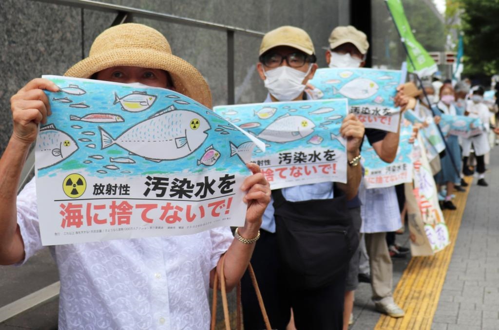 8月24日，日本民眾手持“不要將污染水扔進大?！钡葮?biāo)語在東京電力公司總部前集會，抗議日本政府和東電公司無視民意啟動核污染水排海。新華社記者楊光攝