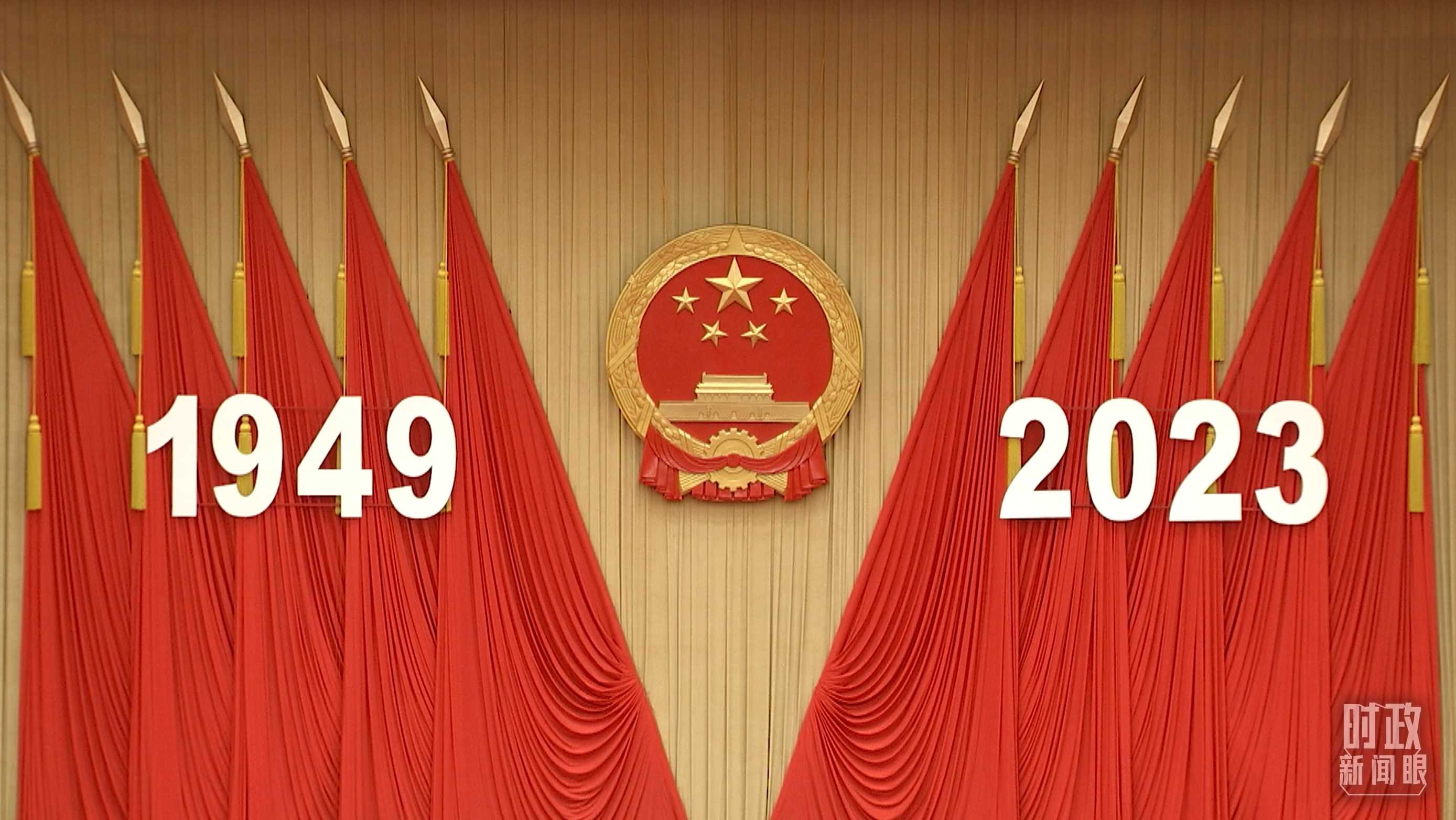 △人民大會(huì)堂宴會(huì)廳內(nèi)，主席臺(tái)上方高懸著莊嚴(yán)的國(guó)徽，“1949－2023”大字年號(hào)在鮮艷的紅旗映襯下格外醒目。