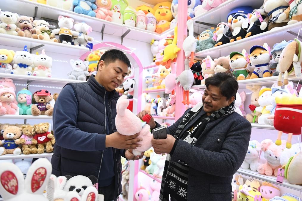 2023年2月2日，來自印度的客商（右）在義烏國際商貿(mào)城的一家玩具店鋪內選購商品。新華社記者 黃宗治 攝