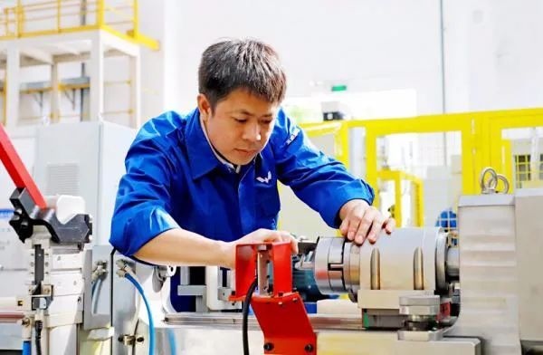 △鄭志明正在對襯套自動壓裝設(shè)備進行檢測調(diào)試。