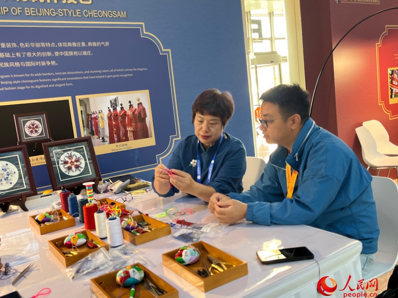 記者在新聞中心非遺傳承人展區(qū)進(jìn)行體驗(yàn)。人民網(wǎng)記者 杜燕飛攝