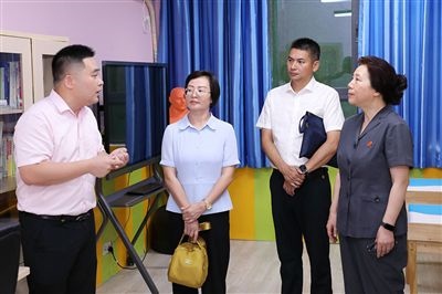 圖③：“小公民法律課堂”開(kāi)講前，全國(guó)人大代表殷其龍（右二）、重慶市人大代表李自玲（左二）聽(tīng)取楊家坪中學(xué)負(fù)責(zé)人關(guān)于未成年人思想教育工作情況的介紹。