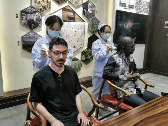 2023“一帶一路”媒體合作論壇聯(lián)合采訪團(tuán)團(tuán)員在九牛草展示館體驗(yàn)艾灸。（本報(bào)記者 黃超攝）