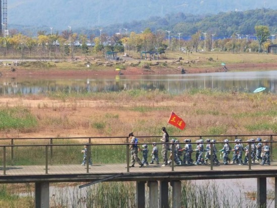 10月24日，秋游的幼兒園小朋友在老師帶領(lǐng)下走在清水塘公園里的木橋上。本報記者 常雯宜攝
