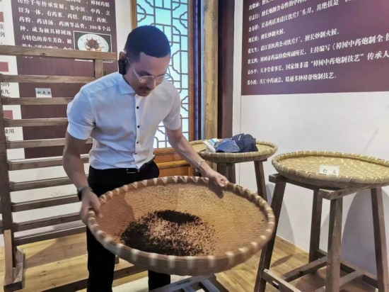 2023“一帶一路”媒體合作論壇聯(lián)合采訪團(tuán)團(tuán)員在非遺文化展示館體驗(yàn)中藥炮制技藝。（本報(bào)記者 黃超攝）