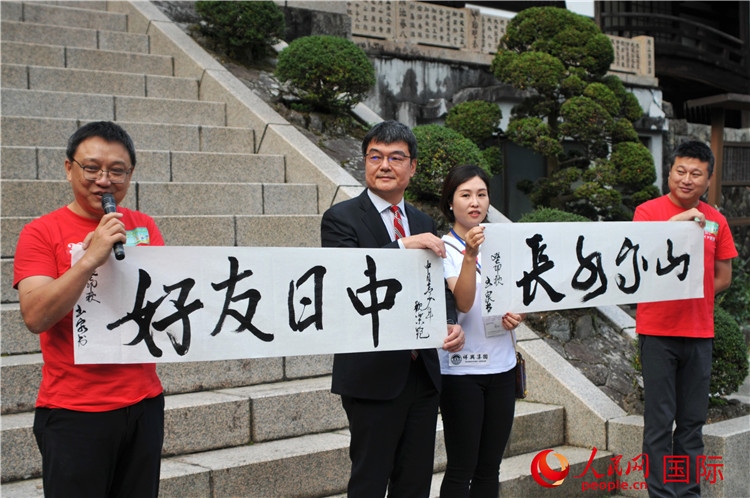 東京中國文化中心主任羅玉泉展示其為本次活動書寫的題詞“中日友好，山高水長”。人民網(wǎng) 蔣曉辰攝