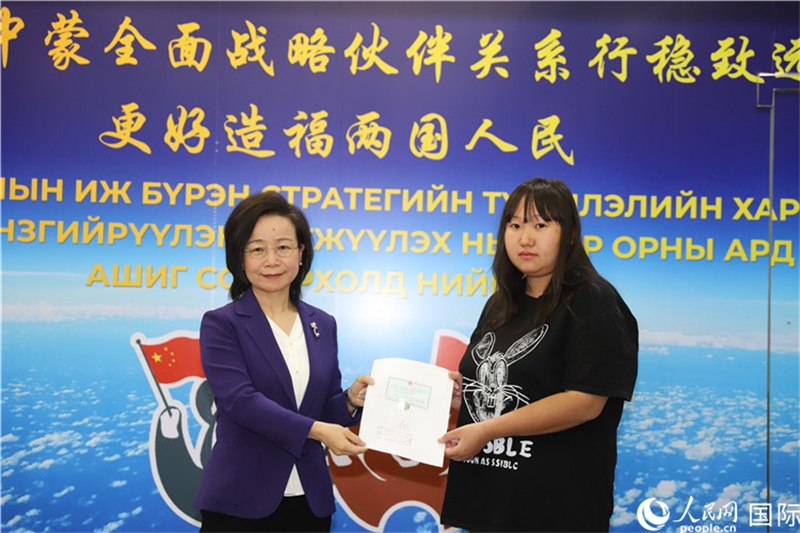 11月10日，沈敏娟大使向蒙古國(guó)公民尼亞姆庫(kù)（右）頒發(fā)最后一份領(lǐng)事認(rèn)證書。人民網(wǎng)記者 霍文攝