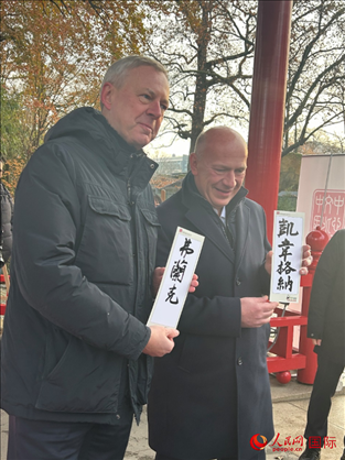 柏林市長(zhǎng)韋格納（右）、動(dòng)物園監(jiān)事會(huì)主席布魯克曼（左）手持中國(guó)文化中心工作人員現(xiàn)場(chǎng)手書的中文名字。人民網(wǎng)記者 徐馨攝