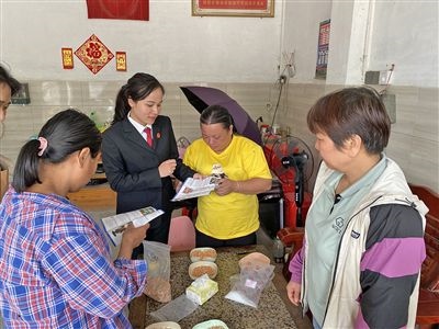  圖⑤：龍圩區(qū)法院法官到群眾家中開(kāi)展法治宣傳。資料圖片