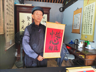 越南首都河內(nèi)文廟內(nèi)，阮明珠展示“中越心相近”書(shū)法作品。