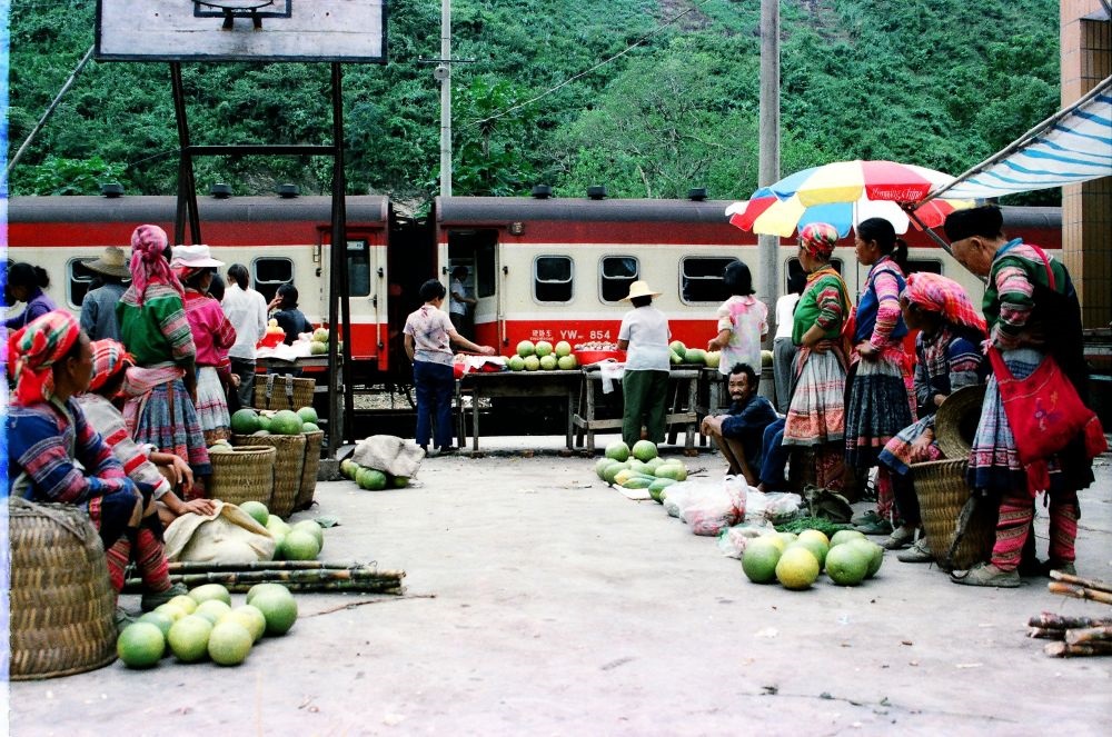 這是90年代中后期滇越鐵路沿線的集市，客運(yùn)列車的開行為當(dāng)?shù)氐拇迕駧砩虣C(jī)。