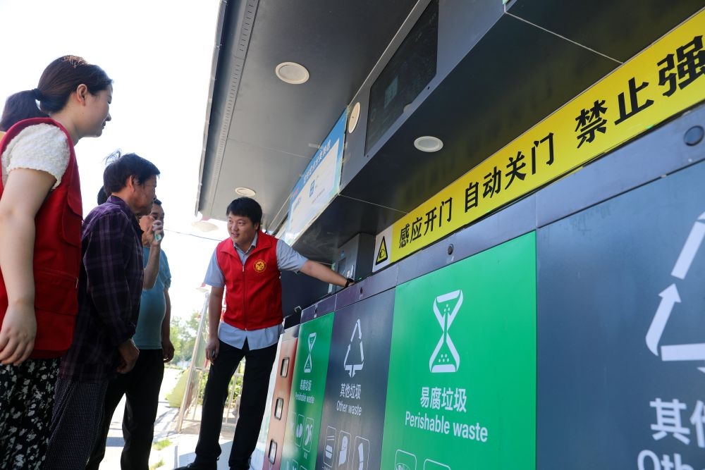 在安徽省合肥市長(zhǎng)豐縣莊墓鎮(zhèn)棗林社區(qū)，志愿者指導(dǎo)居民使用智能垃圾分類回收設(shè)備（2023年9月1日攝）。新華社記者 曹力 攝