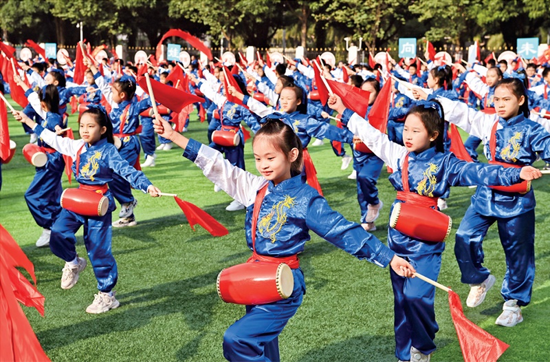 為助推民族地區(qū)基礎(chǔ)教育事業(yè)發(fā)展，廣西重新核定各地中小學(xué)教職工編制，依托全區(qū)編制“周轉(zhuǎn)池”核增事業(yè)編制給各地中小學(xué)，在全面達到國家標(biāo)準(zhǔn)的基礎(chǔ)上，進一步統(tǒng)籌優(yōu)化和動態(tài)調(diào)整各區(qū)域、學(xué)校、學(xué)段間編制資源。圖為2023年11月29日，南寧市濱湖路小學(xué)舉行主題為“逐夢新時代 健體向未來”的體育文化節(jié)，孩子們正在跳腰鼓舞。 新華社記者 周華/攝