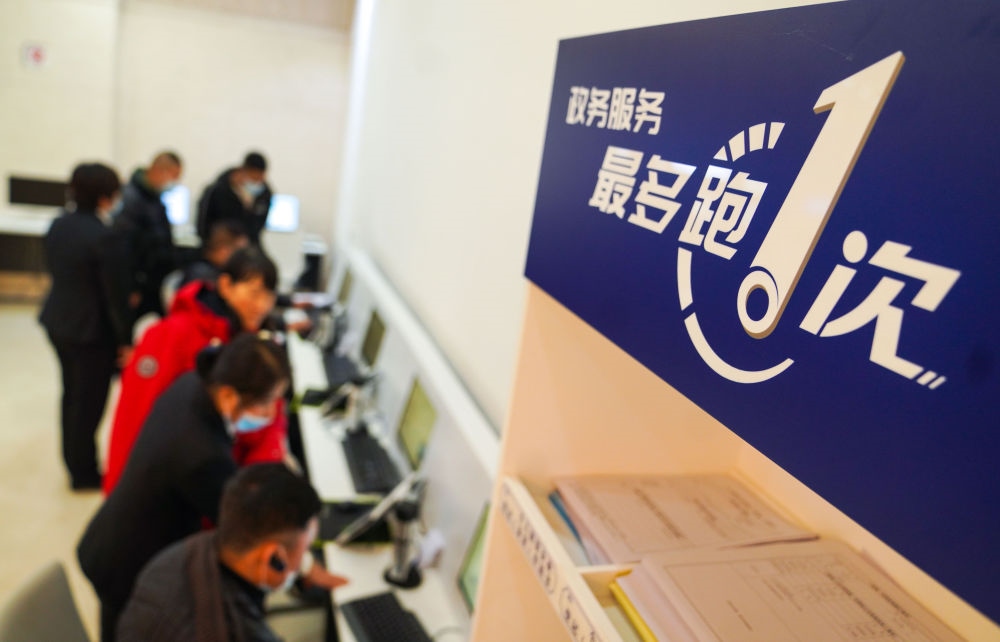 在吉林省長(zhǎng)春市二道區(qū)政務(wù)服務(wù)中心輔助填報(bào)區(qū)，市民在工作人員的輔助下進(jìn)行事項(xiàng)填報(bào)（2020年11月23日攝）。新華社記者 許暢 攝